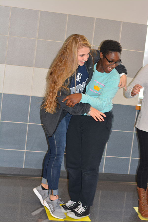 River crossing \\ Making sure not to fall into the “boiling hot chocolate river” for the Wylie Way Day Hot Chocolate River activity, junior Maddison Fraley and senior Phoebe OsBourne try as hard as possible to not fall off one the four marshmallows provided.