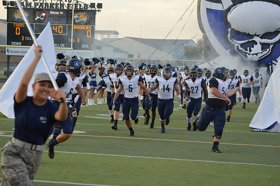 On air \\ The varsity football team storms the field to take on Mt. Pleasant Aug. 31. Coach Mike Dormady chose two players to be featured on 99.5 The Wolf's morning talk show.