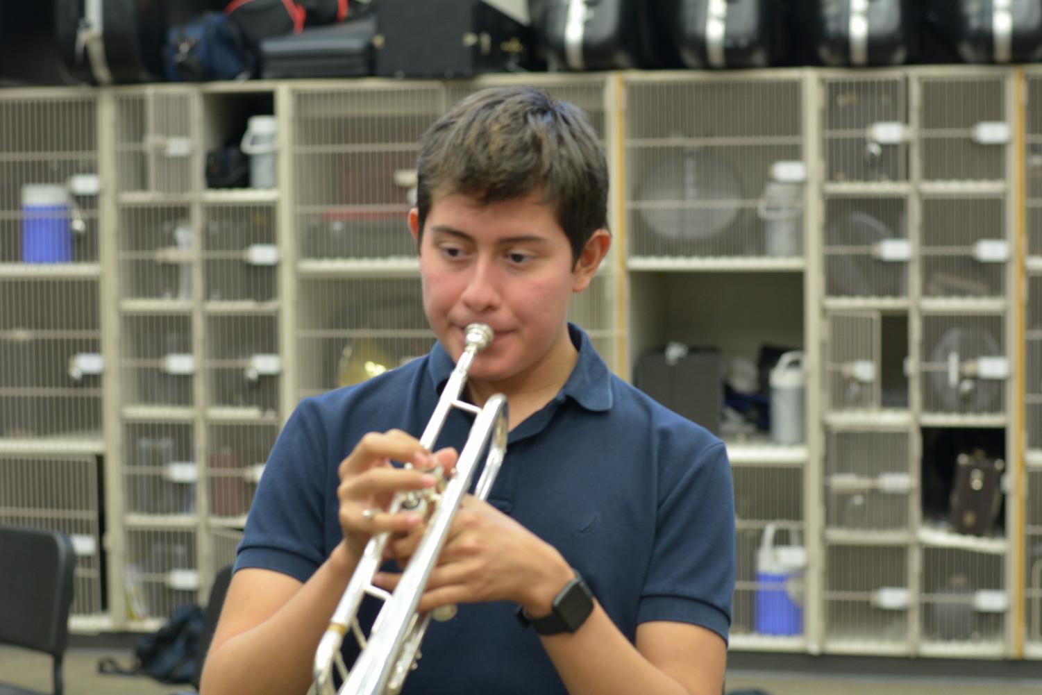 Conquered notes \\ Focusing on his music, junior Ivan Najera plays a movement from his marching band show. The band’s show this year is entitled Conquered featuring music from The Prince of Egypt and The Wind and the Lion. Najera missed over 60 days of rehearsal due to fighting cancer but still managed to learn the show music. “I really enjoy playing music from movies I watched as a child, and it’s a lot more fun than last year’s,” Najera said.