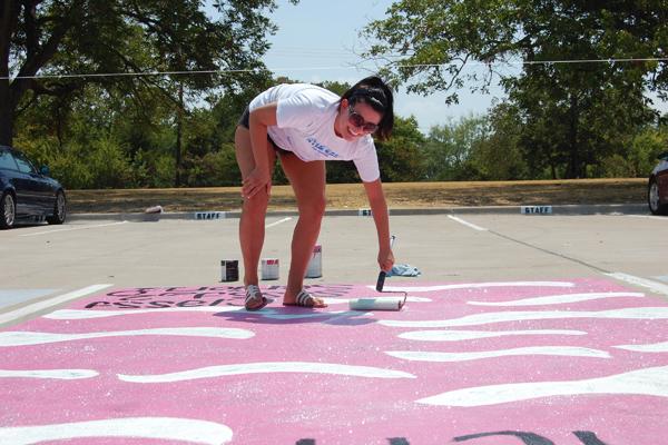 Students battle the heat to paint parking spots