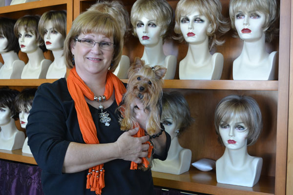 Gale Smith stands in front of the wigs of her shop, Amazed by You, that she founded after she was diagnosed with cancer.