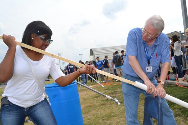 Dr. Best illustrates how to use the potato launcher to a student in his physics class. He also teaches earth, space and science.