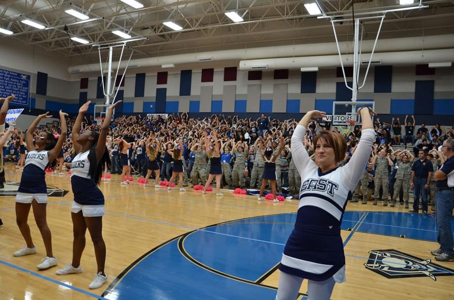Part of the squad \\ Borrowing a uniform from varsity cheerleader Kyleigh Anderson, New Assistant Principal Dr. Amy Burkman rumbles with the students at the East versus High pep rally Oct. 3.