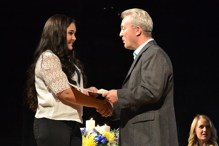 Welcome to the society \\ Senior Samantha Redig is inducted into the National Honor Society. Principal Mike Williams congratulated each inductee on stage in the auditorium Nov. 17.