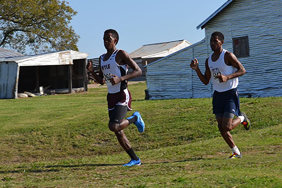 Across the country \\ 
Running at the district meet, senior varsity runner Edwin Walker competes against a Wylie High student. Walker accomplished his goal of winning district champion, but fell short for the district title. 
