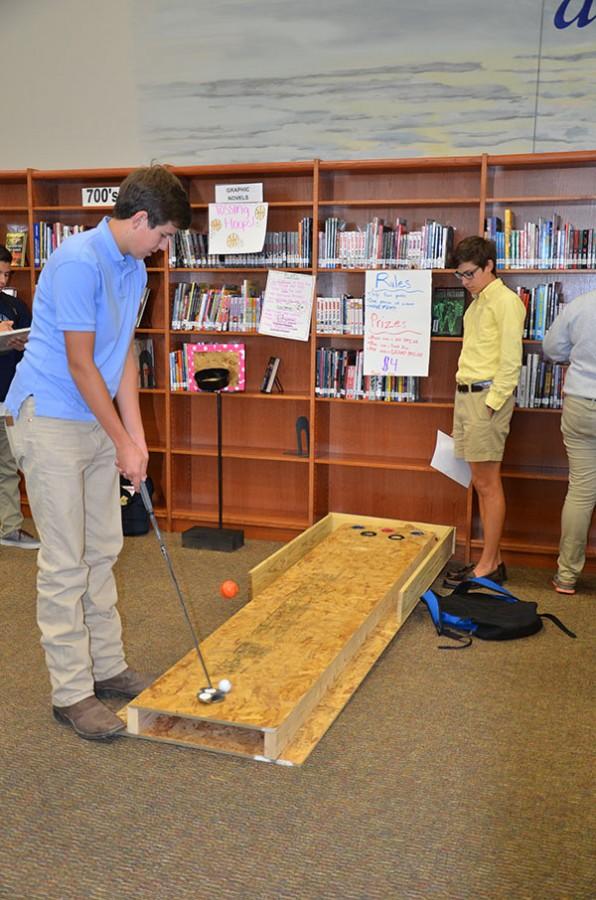 Putt putt for probability \\  Seniors Clayton Lindsey and Zack Zambrana test the empirical probability of their putt-putt game for advanced quantitate reasoning class. It took place in the library Nov. 12 as a project.