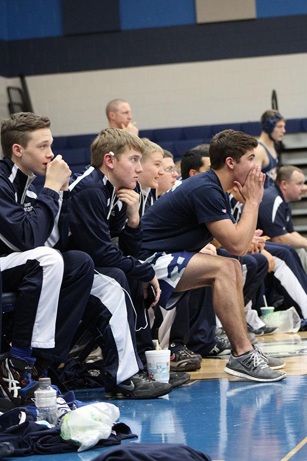 Nail biting // The team sits and watches anxiously as a teammate takes on his opponent at the dual versus McKinney North hosted at East Jan. 8.