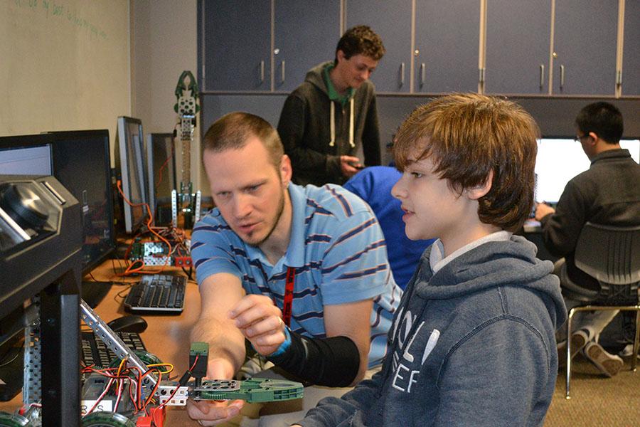Bet your bot \\ Dr. Jacob Day instructs freshman Shain Brown on how to make corrections to his robot in concepts of engineering March 31.