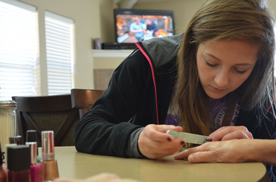 Nailed it \\ Reaching out to retirement homes, Interact Club visits Mayberry Gardens. Senior Jackie Scanlon paints the nails of one of the residents.