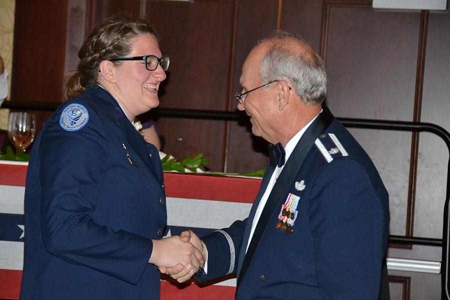 Its rocket science \ Colonel Wayne Wilbanks congratulates junior Elisabeth Teitelman for winning an outstanding cadet award in Aerospace Science II at the annual Dining Out event May 17.