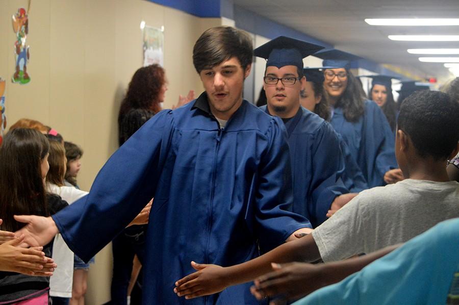 Hands in \\ Walking through his old elementary hallways, senior Tyler Lanier is congratulated by current Birmingham Elementary students. He was in a tragic car accident one day after graduating.