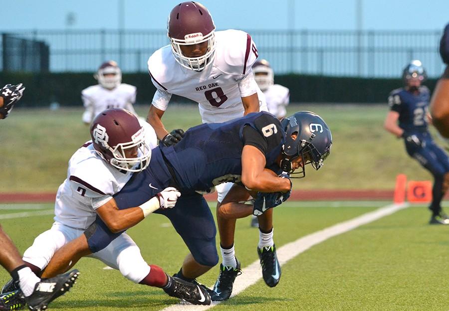 Getting past the goal line, senior Jared Wyatt scores a touchdown after catching a pass to take the 14-0 lead against the Red Oak Hawks. Varsity defeated Red Oak 49-7 at the season opener Aug. 28 at WISD stadium.