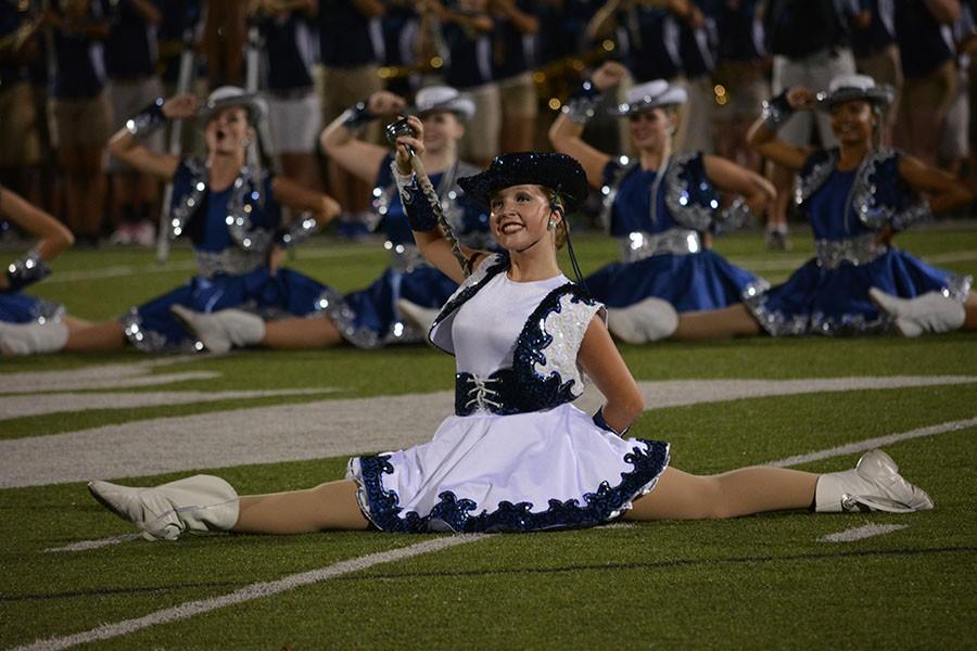 Got to split \\ Showing off the opening dance, senior Lieutenant Kaitlyn Smith smiles at the crowd before continuing the performance Sept. 10.