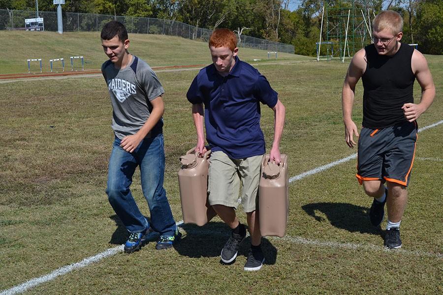 Jug jog // JROTC students run with 40 pound water jugs to the 20 yard line for the army recruiters’ team building activity. Each activity was timed to compete with the other groups in the students’ flight and represented a situation that may occur on an active battlefield. 