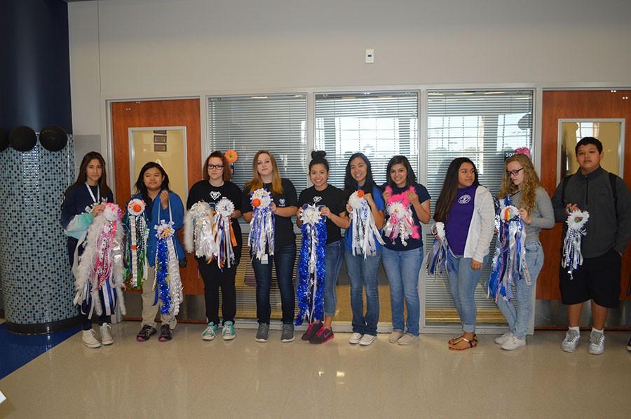 Mum-mania // Interact club members prepare to give their hand-made mums to students the morning of Homecoming Oct. 16. This year marks the fourth year the club has created mums and garters for others, which has led to their well-known mum making tradition.