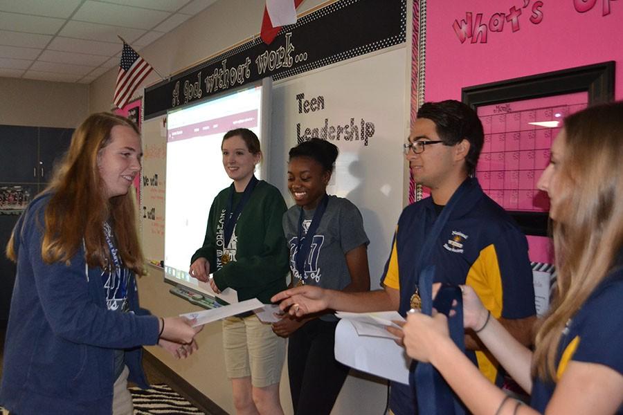 Medaling \\ National Honor Society officers tap new members Oct. 28 by surprising them with the news they qualified to be in the prestigious organization.