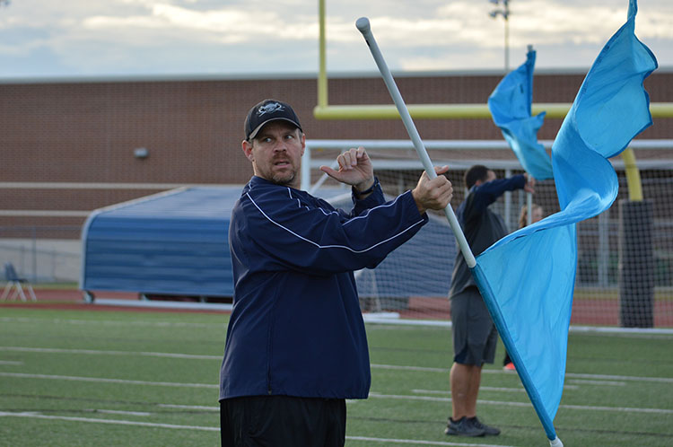 Football to flags \\ Football Coach Gary Porter spins flags at the March A Spot Nov. 6. Band students, colorguard and Sapphires invited teachers to switch roles with them.