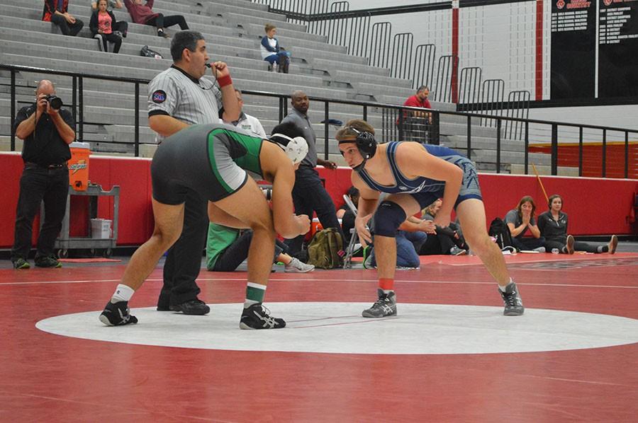 Ready Stance \\ Senior Dylan Hoffard looks his opponent in the eyes intimidatingly as he waits to begin his final match at the Colleyville wrestling invitational. 