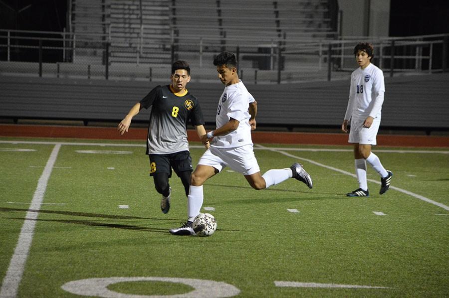 Keep away // Passing up the field, junior Mauricio Jimenez kicks the ball to get it down to a fellow teammate to try and score a goal Jan. 19. The team fell short 2-0 against Mount Pleasant at Wylie Stadium.