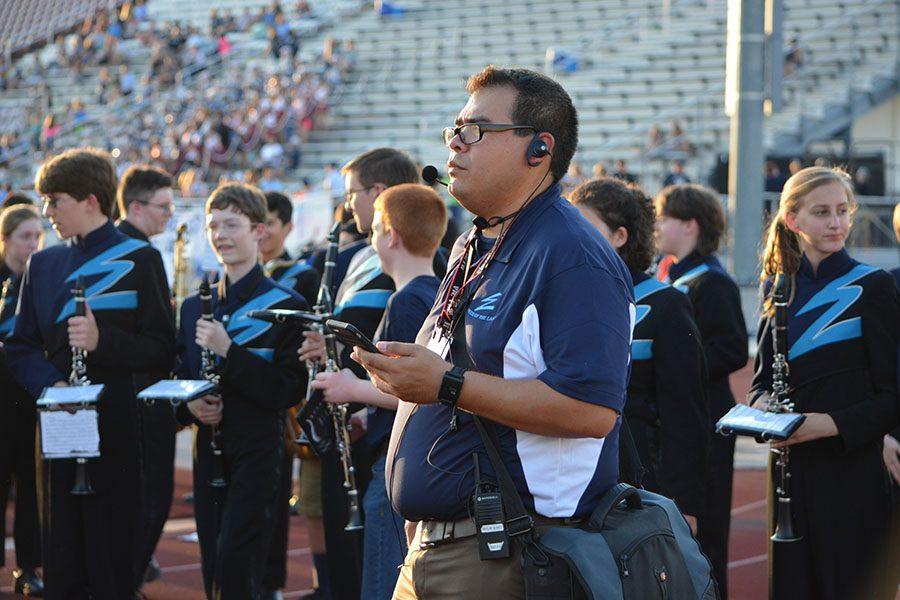 Fresh Arcs \ Waiting for his que, Band Director Mr. Saldana forms the band students into an arc before they practice with eighth-graders at the Varsity Football game Sept. 16.
