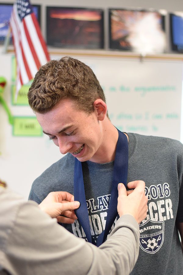 Medaled \\ Receiving his medal, junior Kyle Sproul finds out in Mr. Yeatts class that he made it into NHS at the surprise tapping Oct. 28.