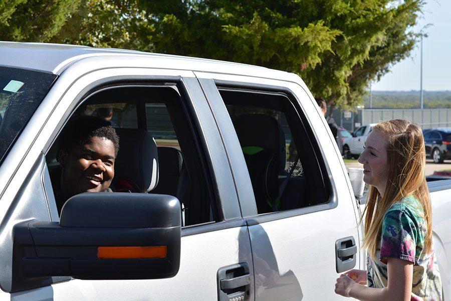 Simulating smiles // Engaging in the mock traffic stop, sophomore Sara Johnson and junior A.J Bankhead simulate violator contact during an exercise Oct. 24.