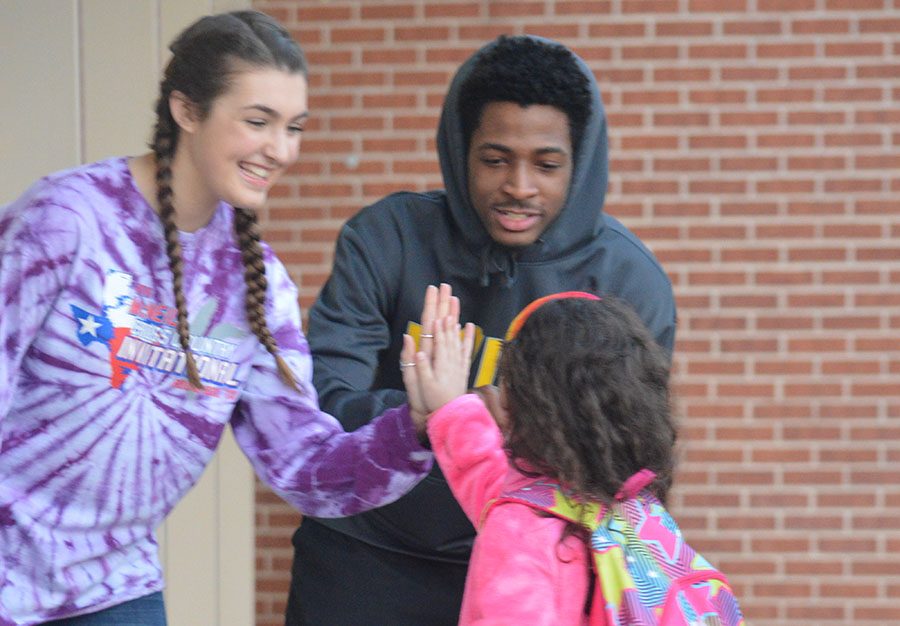 Morning smiles \\ Sophomore Haylie Hadjev and junior Jai Shoin Mathis welcome and open doors for Cox Elementary students Jan. 12.
