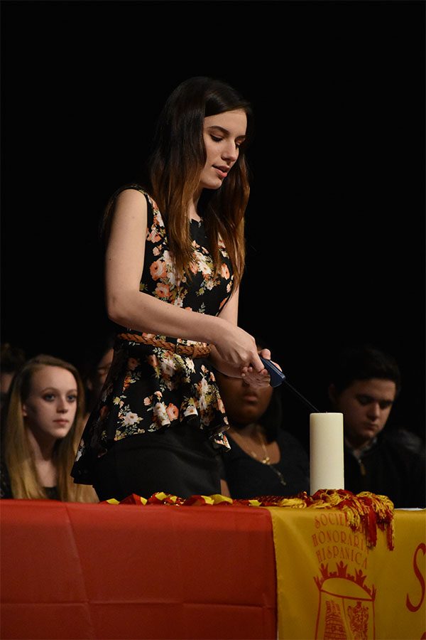 On fire \\ Junior Kate Sheets lights the ‘mother candle’ at the Spanish Honor Society induction. Forty three new members were inducted Feb. 23.