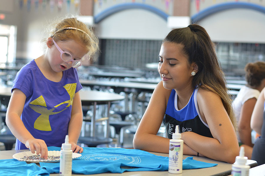 Bling Party / / Listening to her Junior Jewel, freshman Gabby Mellado watches her place rhinestones on her shirt. The Sapphires hosted a clinic for elementary and intermediate school girls Saturday, Sept. 23. The attendees learned a dance to a remix of Moana’s How Far I’ll Go and will perform it at the Sept. 28 football game.