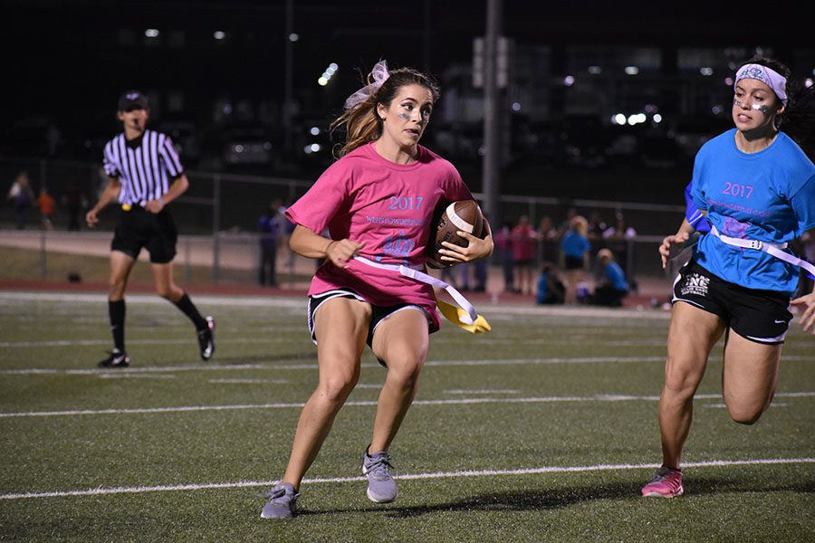 Break away \\ Rushing to the outside, senior Madison Dorethy looks to juke out senior defender Madison Donaldson in the first Powderpuff football game. The Blue Team defeated the Pink Team 16-11 Oct. 6.