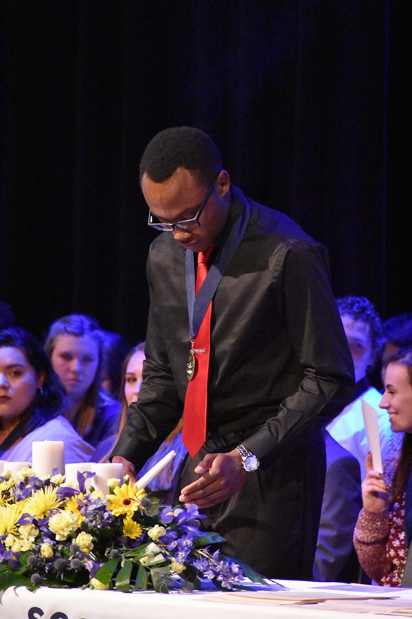 Light it up // Lighting the candle, senior NHS president Obinna Ejikeme starts the NHS induction ceremony Oct. 30. NHS inducted a total of 94 new members. Photo by Harper Taylor