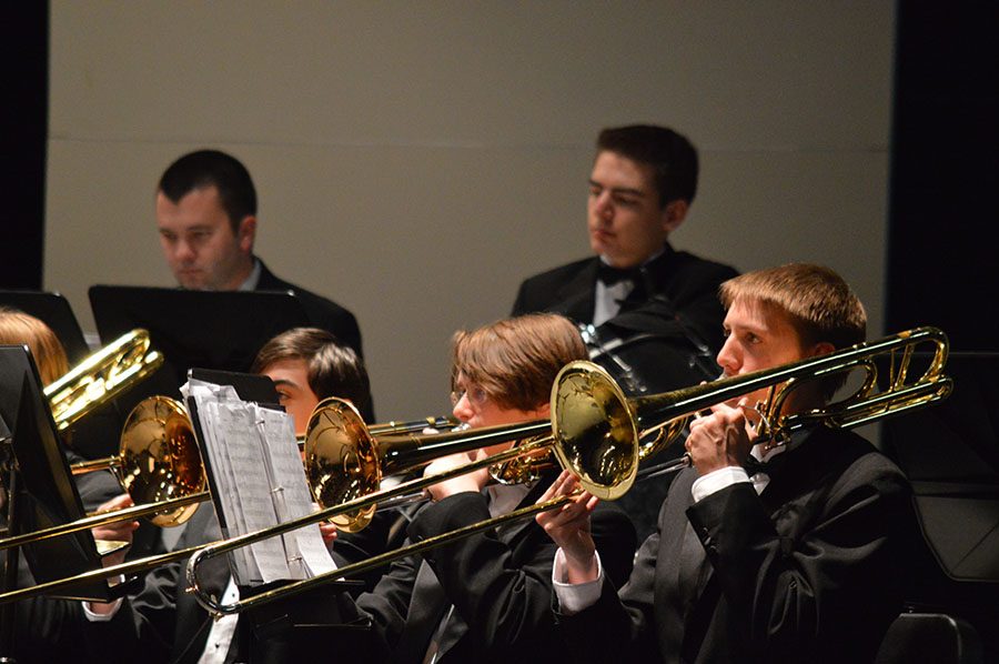 Summer dances // Playing the trombone, freshman Thomas Freeman looks up at the director to keep time. The Wind Ensemble played at the Mid Winter concert Feb. 13, preparing for UIL in March. 

