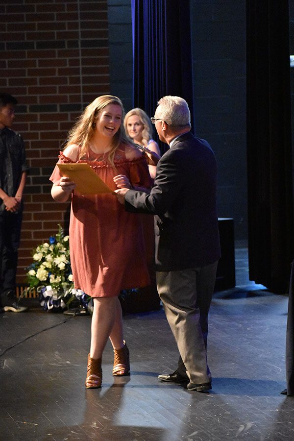 Last laugh // Junior Jordan Smith smiles as she accepts the Honor Roll certificate from Principal Mike Williams at the Raiders Excellence Award Ceremony April 30.
