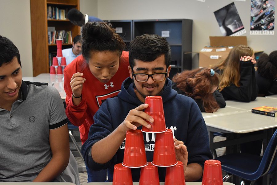 Concentration \\ Senior Nikki Vernon coaches senior Darrek Montanez through the cup stacking activity during Wylie Way Day Sept. 12. In English, students learned how to maintain character and integrity as they pursued excellence in what humans do. The activity was a game called cup stacking. 
