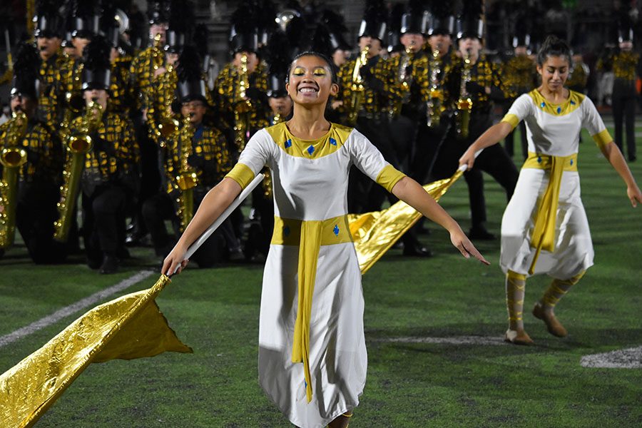 Showing off \\Freshman Aileen Khuu performs Conquered at half time during the homecoming game. The high standards of the colorguard have only improved their performances.