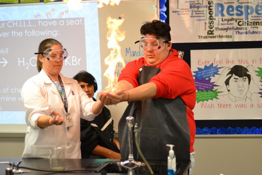 Hands-on experience \\ Mrs. Groter ignites methane on sophomore Jonathan Portillo’s hand. The lab allowed students to get an up close look of the concepts they learned. “It was amazing. It didn’t hurt at all,” Portillo said. 