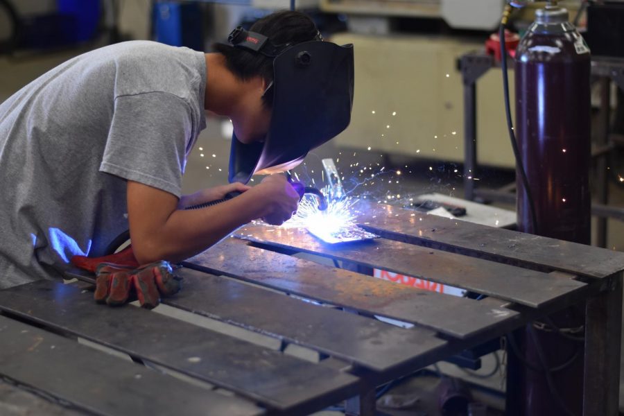 Spark off // Junior Wen Liu utilizes a TIG welder to perfect his welding technique for the skull. Students in Mr. Roseberry’s advanced welding classes are building a 8 foot tall metal skull to display in front of the school.