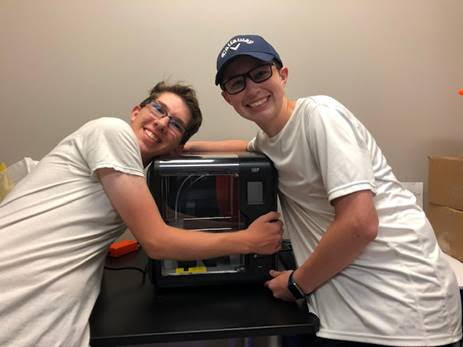 3D love \\ Senior Collin Kaiser and sophomore Cade Swanson celebrate their new 3D printer by hugging it in Mrs. Lawrence’s engineering class.
