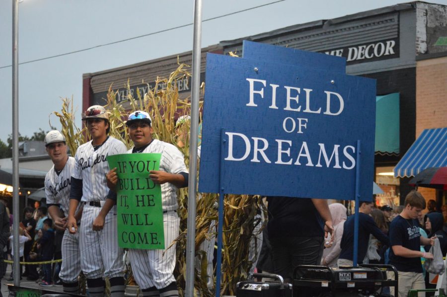 Holding truths \\ Parading downtown, the baseball team’s float themed “If you build it, he will come” refers to the movie, Field of Dreams, keeping in sync with the homecoming theme of Lights, Cameras, Raiders! Judged by Mayor Eric Hogue, the team won first place for their float. 