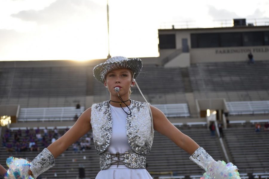 Golden Hour \\ Leading victory lines, Sapphire Captain Berry Stevens whistles to signal the next ripple for the team at the varsity football game against Woodrow Wilson Oct. 11. The team travelled two hours to perform a team pom to the song “Pretty Fly.”