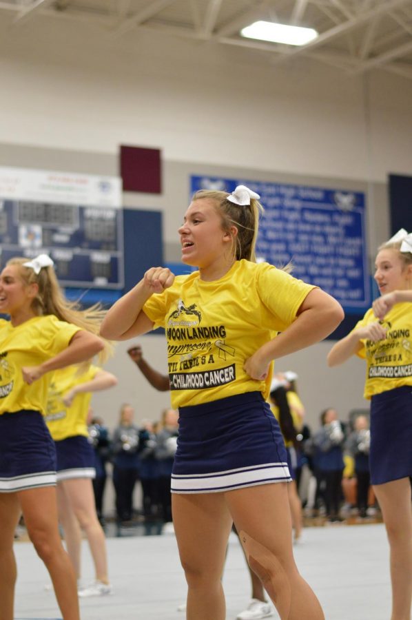 Battle Cry \\ Leading the crowd in a chant, sophomore Campbell Andrews shows her school spirit at the Gold Out pep rally Sept. 6. This is Andrews’ first year on varsity cheer. “I’ve grown so much as a person being on varsity,” Andrews said.