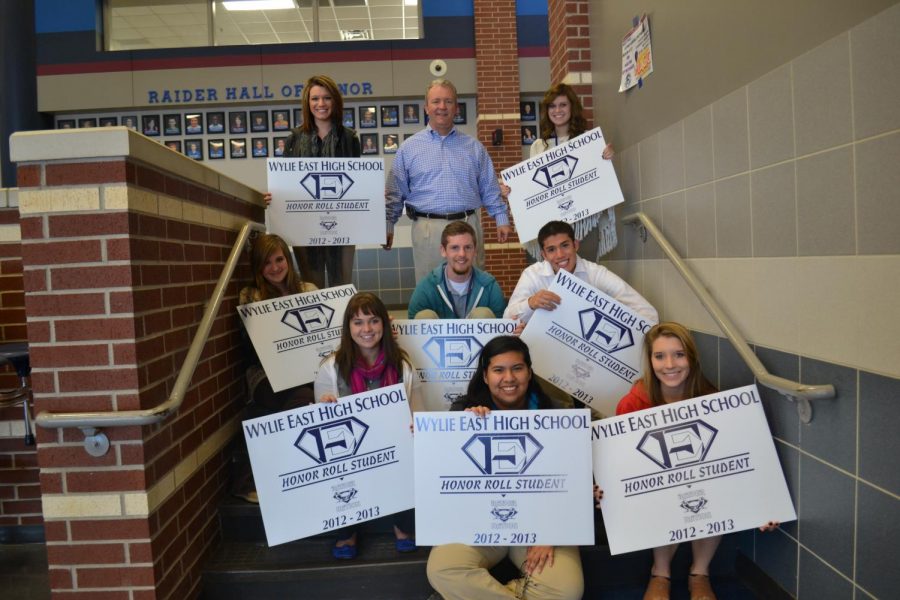 On a roll \\ Mr. Williams poses with the first students to receive yard signs for making the honor roll.