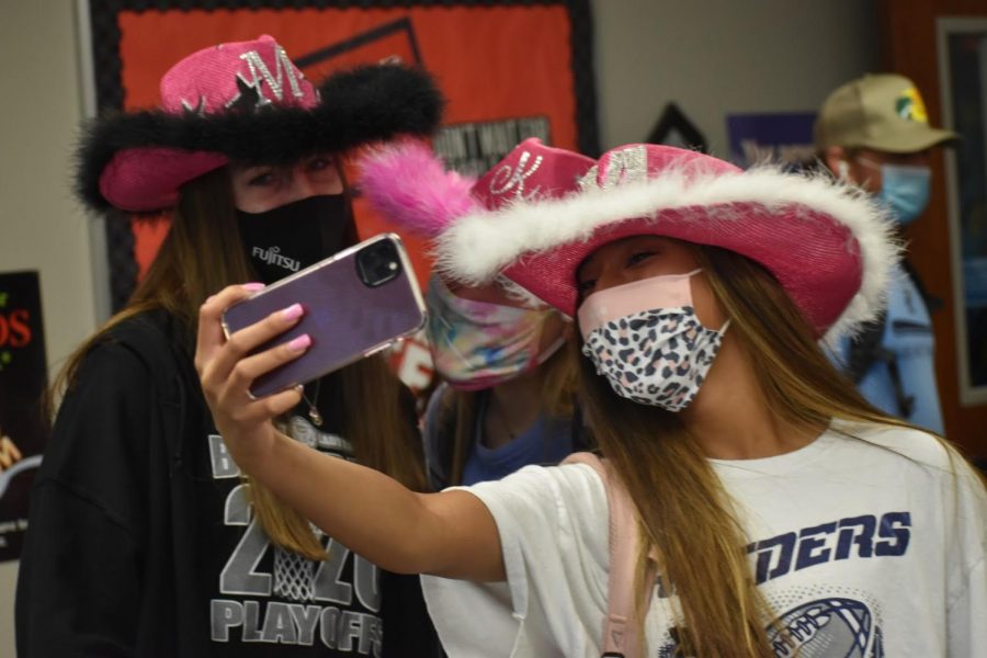 Spirit selfies \\ Displaying their festive hats, seniors Mya Jones, Morgan Healey and Kayla Green, take a picture with their pink, self-decorated cowboy hats to show their school spirit during the first spirit day of the school year, Hat Day, Aug. 21. Wylie High and East joined together for mutual commUNITY spirit days.