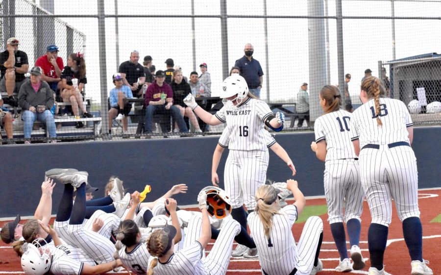 Drop it like it’s hot \\ Falling to the ground, the varsity girls softball team reacts to junior Andrea Bolings home run. The team played a home game against The Colony and lost by one run, 8-7 April 9.

