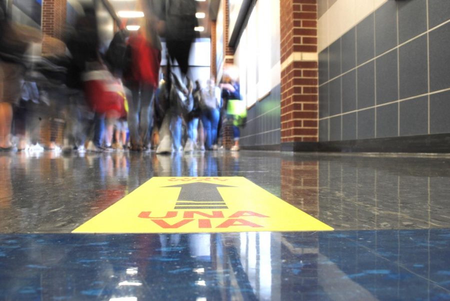 Footsteps // Students walk in the 800 hallway between fifth and sixth period Sept. 11. Signs on the floor and walls designate the direction students need to walk in as part of the new measurements to ensure social distancing.