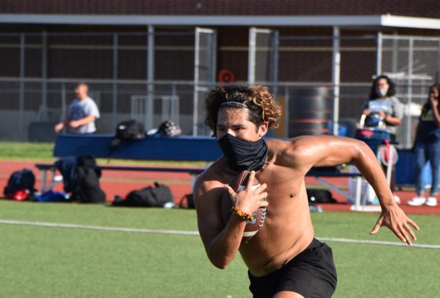 On the run \\ During an after school football workout, senior running back Sergio Aguero, practices without pads, but with his face mask to abide by the new UIL regulations Aug. 17. 