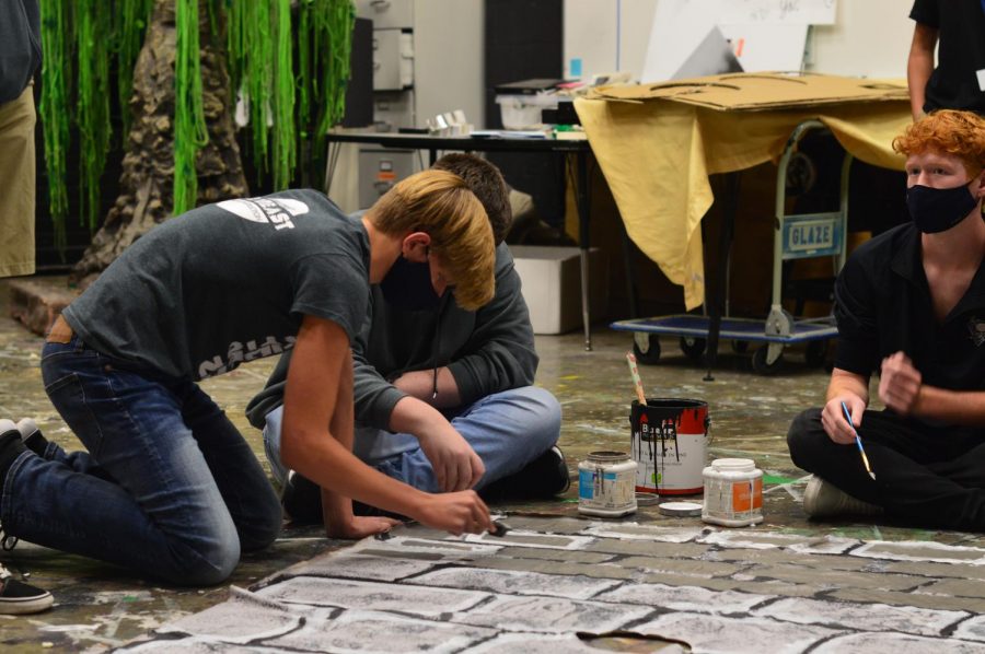 Setting a scene // Painting the set for the upcoming show, Midsummer Nights Dream, sophomore Jude Kurtz adds his finishing touches to the set building. Thespians will perform Shakespeare in the Park Monday, Oct. 12 at Founders Park.