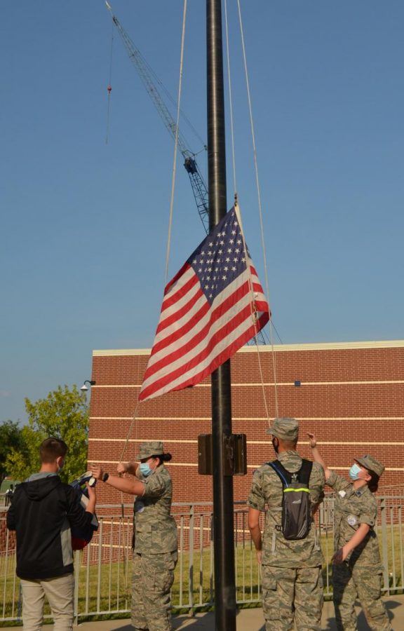 Raise up \\ Senior Arlin Granados and juniors Nick Garcia and Mikaylee Adams conduct flag procedures such as taking down the American flag to fold Aug 16. “Teaching the freshmen to properly fold the flags and watching them do it correctly feels amazing,” Garcia said.