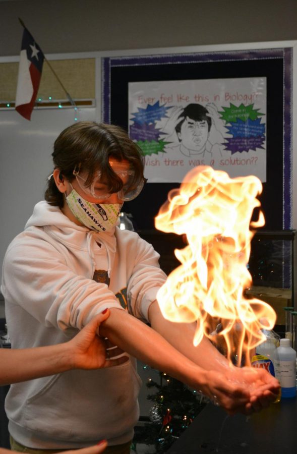 Catching fire \\ 
Participating in Mrs. Lissa Groter’s fourth period chemistry class, sophomore Traviss Ragan has the butane-filled bubbles in his hands lit at a station during a lab Dec. 3. “I definitely liked the fire part and we got to burn this piece of metal with chemicals on it,” Ragan said.