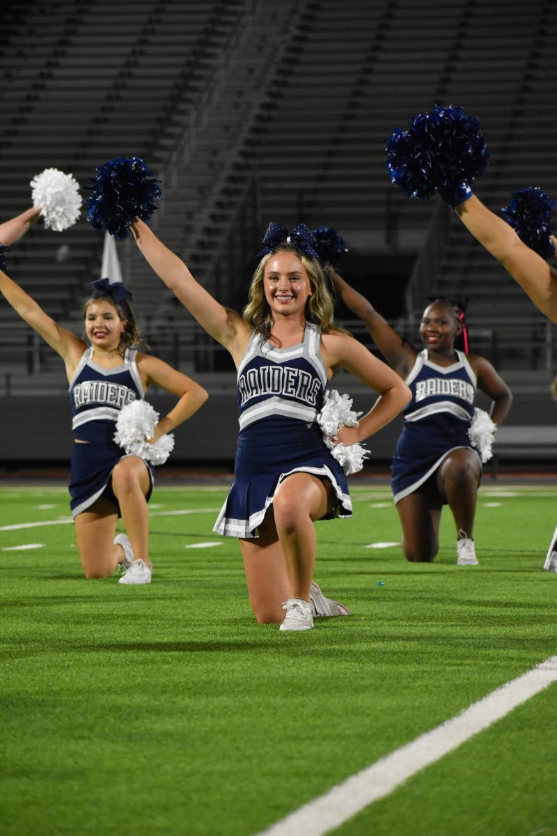 Raider spirit \\ Performing at Meet the Raider, junior Kennedy Johnson cheers on the field Aug. 17. Meet the Raider showcased the Sapphires, Cheer, and the Football team. My favorite thing about cheer is the bonds you create along the journey and the memories made that will last forever, Johnson said. 